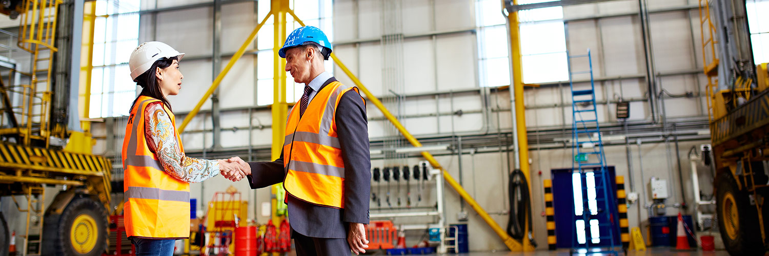 An ISO consultant shaking hands with a client on a factory floor